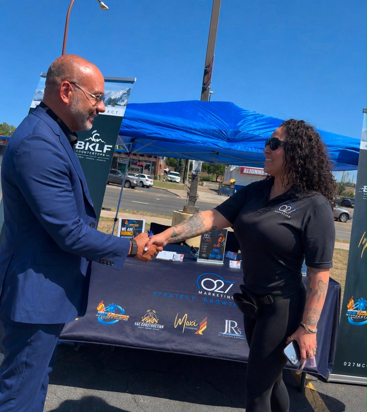 027 Marketing representative greeting a client at a Colorado trade show booth
